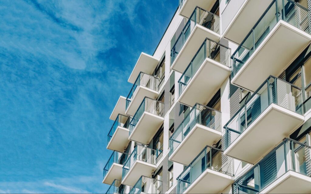 Modern luxury condo developments in Clearwater featuring white balconies and glass railings against a clear blue sky, illustrating the rise of high-end coastal living for 2026.